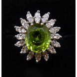 An 18 carat gold peridot and diamond flower form cluster ring, size K, 7.5g