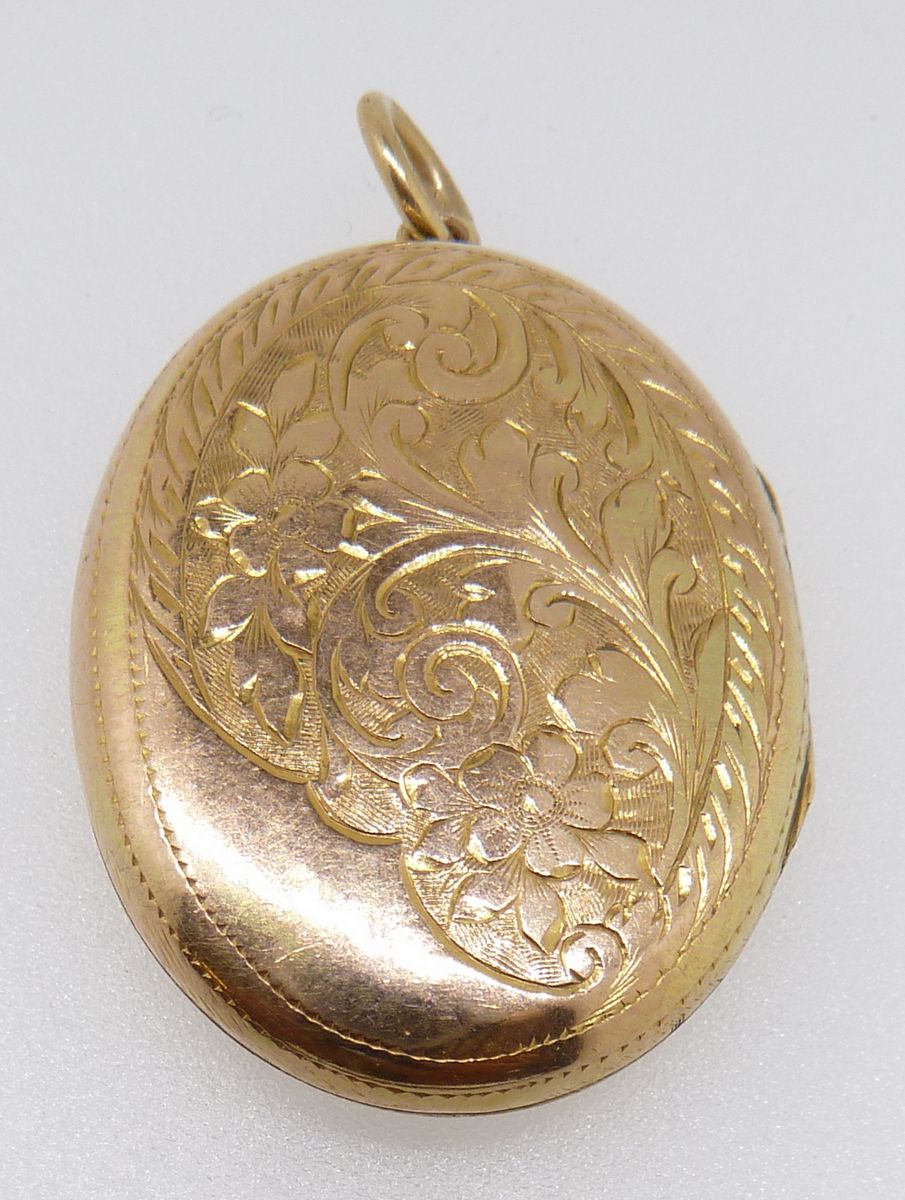 A gold oval locket with engraved decoration, 5.5g, 3 x 2.3cm
