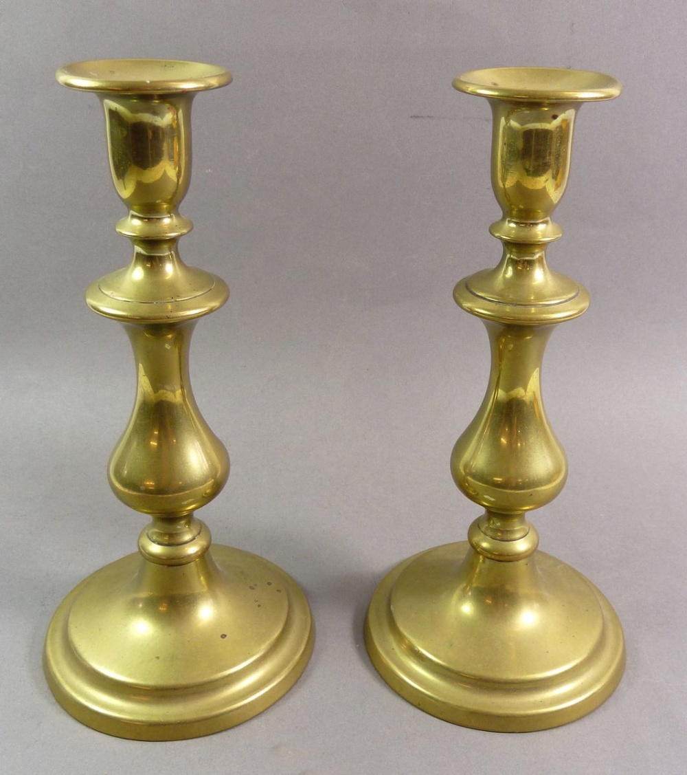 A pair of brass candlesticks 23cm tall