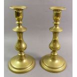 A pair of brass candlesticks 23cm tall