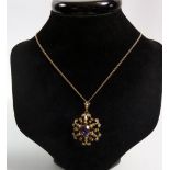 An Edwardian 9 carat gold amethyst and seed pearl pendant/brooch on 9 carat gold chain in original