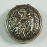 A white metal pill box embossed Francis of Assissi, 3 cm diameter