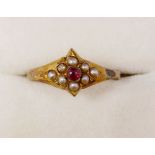 An Edwardian 9ct gold ring set red stone in seed pearl lozenge surround, size K