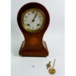An Edwardian mahogany balloon form clock with satinwood paterae, 31cm, with key and pendulum