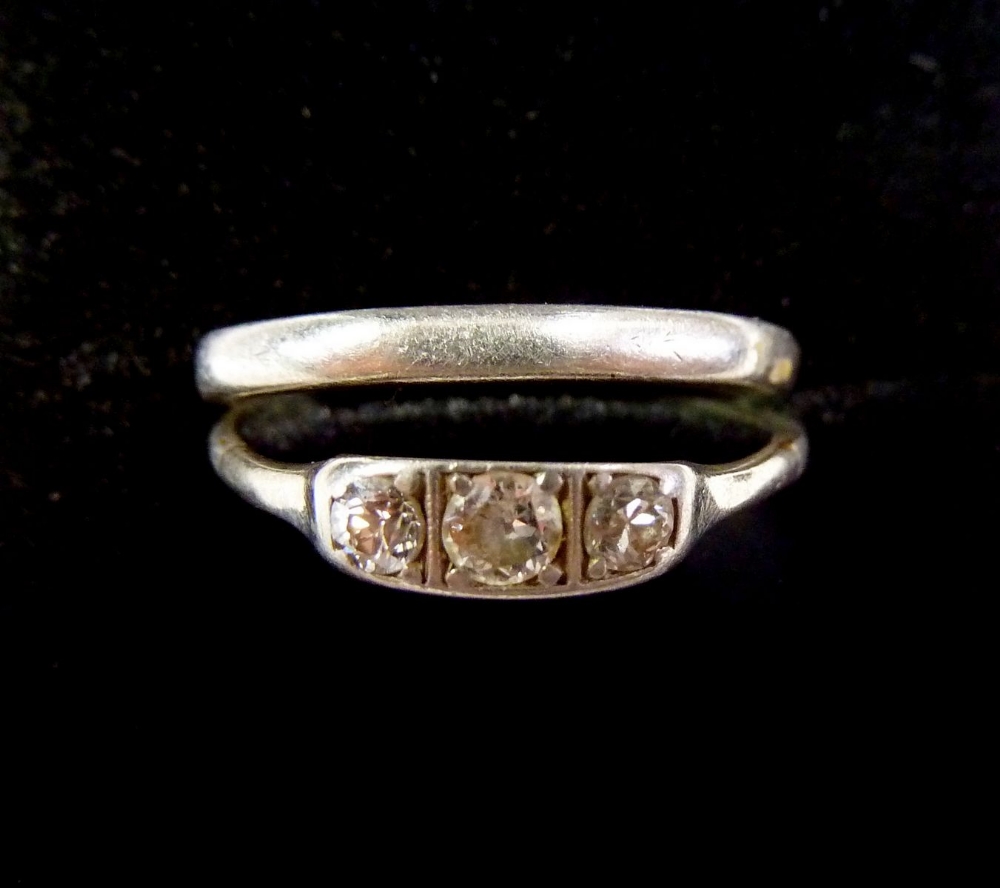 A platinum three stone diamond ring, size M, 1.8g and a platinum wedding band, size N/O, 3.5g
