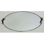 A vintage oval framed mirror with silver plated frame flanked by cast figures, 70cm wide