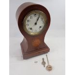 An Edwardian mahogany balloon form clock with satinwood paterae, 31cm, with key and pendulum