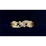 A 9 carat gold ring crossover set three diamonds, one deficient, decorated pierced surround, 1.4g,