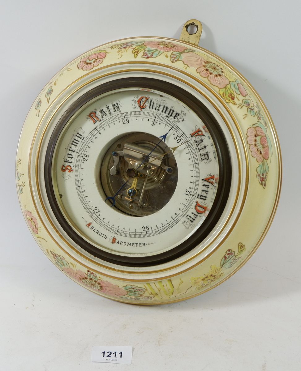 An Edwardian floral pottery framed aneroid barometer 28cm diameter