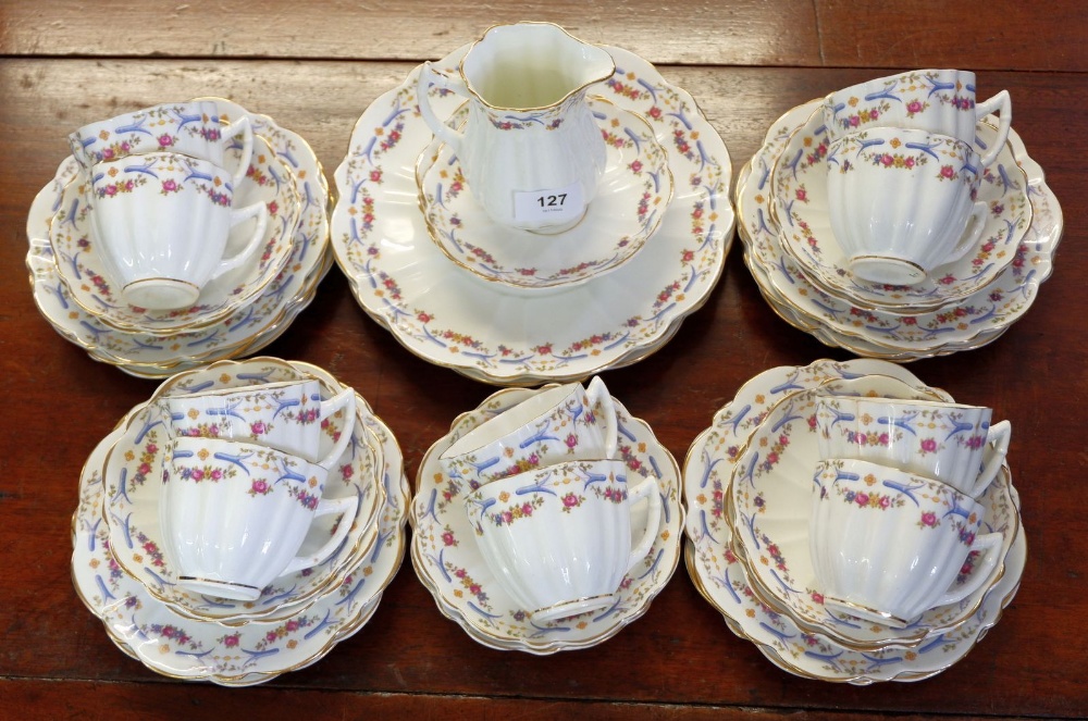An Edwardian blue and pink floral tea set comprising: ten tea cups, twelve saucers, twelve side