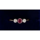 An 18 carat gold ring set red stone flanked by two diamonds, size L-M, total weight 2g