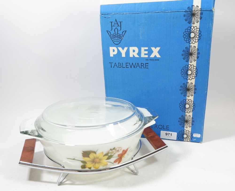 A Pyrex vintage floral printed casserole dish on stand, boxed as new