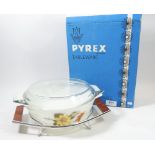 A Pyrex vintage floral printed casserole dish on stand, boxed as new