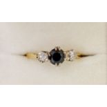 An 18 carat gold ring set sapphire flanked by two diamonds, 2.4g, size N