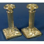 A pair of silver column form candlesticks with rams head decoration, Birmingham 1909, 13cm tall