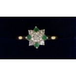 An 18 carat gold emerald and diamond cluster ring, size P