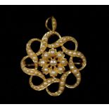 A Victorian 15ct gold circular brooch pendant set seed pearls with central floral cluster within