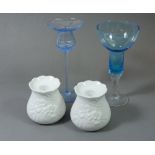 A pair of Kaiser porcelain floral candlesticks and two blue glass ones