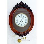 A French oval mahogany wall clock by 'Martin, Baskett and Martin' in floral carved and glazed