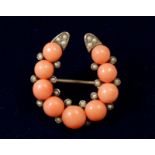 A Victorian yellow metal coral and seed pearl horseshoe form brooch, 2.7 x 2.5cm