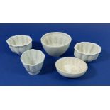 A collection of four miniature pottery jelly moulds, largest 10cm wide and a Shelley one