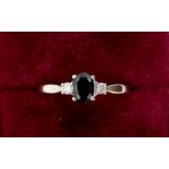 A 9 carat white gold ring set oval cut sapphire flanked by two diamonds, 2.1g, size R