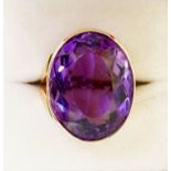 A 9 carat gold handmade large oval cut Brazilian amethyst ring with deep engraved band setting
