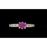 A 9 carat white gold ring set oval cut pink sapphire on diamond chip shoulders, size O to P