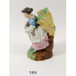 A 19th century porcelain figure of a woman harvesting oranges, 12cm tall