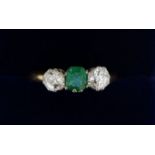 A 18 carat gold ring set emerald flanked by two diamonds (each .4cts each), size O