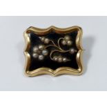 A gold and enamel mourning brooch set seed pearls