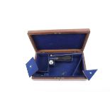 A Walnut veneer pistol case with blue baize lined fitted interior, the lid with inset vacant brass