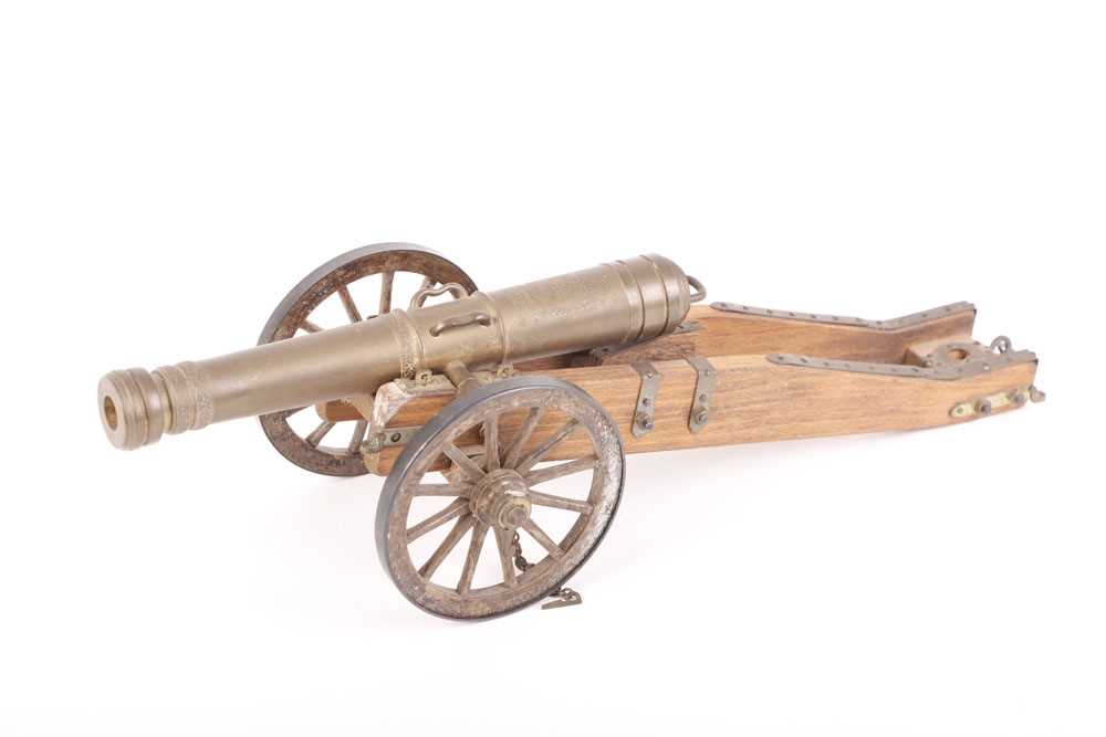 A model cannon, with 6½ ins barrel, on a wooden carriage with brass fittings