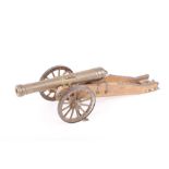 A model cannon, with 6½ ins barrel, on a wooden carriage with brass fittings