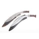 Two kukri knives, each with approx. 13½ ins blade with carved handles, leather covered wooden