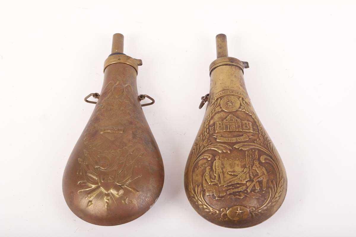 Two brass American powder flasks with embossed decoration and suspension rings