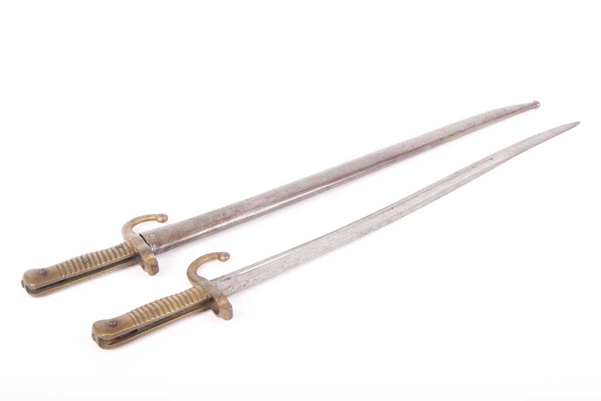 Two Chassepot bayonets, each with a 23 ins slightly curved and fullered blade, brass grips, one with