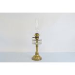 A 19th Century brass oil lamp, having clear glass faceted reservoir over moulded column support on