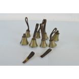 Eight hand bells, six with leather hand straps, two detached
