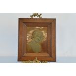 Two embossed Art Nouveau oak framed copper panels, the embossed panels depicting portraits of