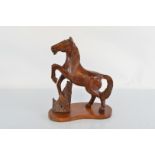 A large wooden carved horse figure, on fixed base. (af to right ear) 41cm tall x 35cm long