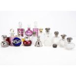 A collection of perfume and scent bottles, including several with silver caps and mounts, some