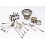 A small group of silver, including a pierced bon dish, toast rack, two napkin rings and several