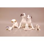 Three Royal Copenhagen porcelain figures of puppy dogs, the largest with two puppies with a bone,