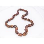 A string of copal amber beads, the carved large baton beads knotted strung, united with a screw