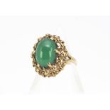A 1970s 9ct gold dress ring, with green cabochon chalcedony in claw setting in raised textured