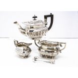 An Edwardian silver three piece bachelor tea set by W.A, half fluted with egg and dart rims,
