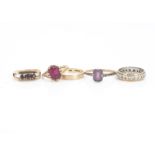Four gem set dress rings, including a 9ct gold garnet three stone ring, a paste set 9ct gold ring,