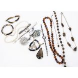 A collection of costume jewels, including tiger's-eye necklace, glass amber beads, brooches and