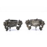 A pair of late 19th century Chinese white metal salts, 5.5cm wide, circular bowls supported by three